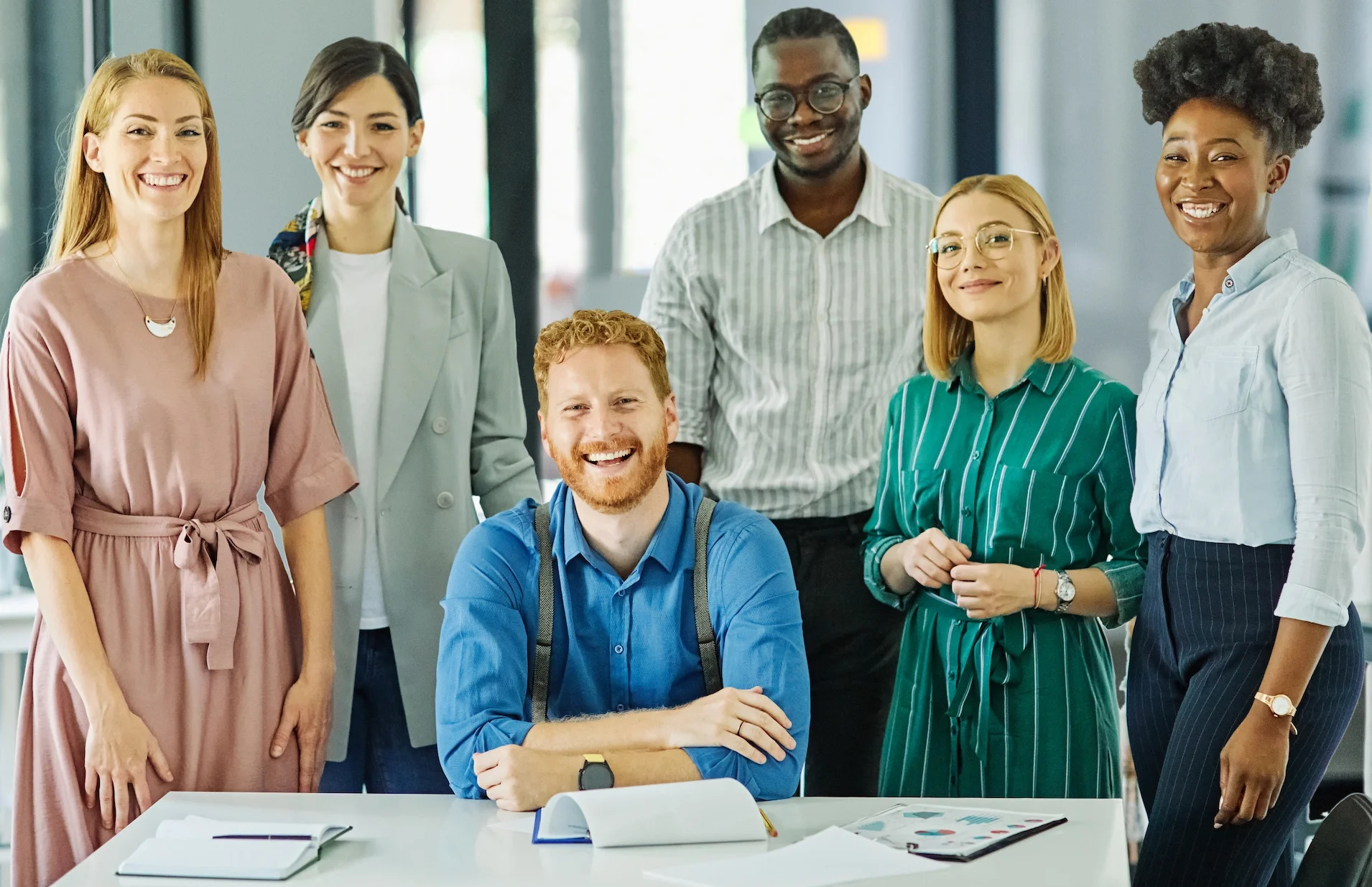 Um grupo diverso de profissionais está reunido em um ambiente corporativo moderno, sorrindo e transmitindo confiança. A cena ilustra a proposta de uma agência parceira que atua em modelo White Label, como a Kodevo, oferecendo suporte estratégico para empresas que buscam ampliar resultados digitais com uma equipe especializada e acessível.